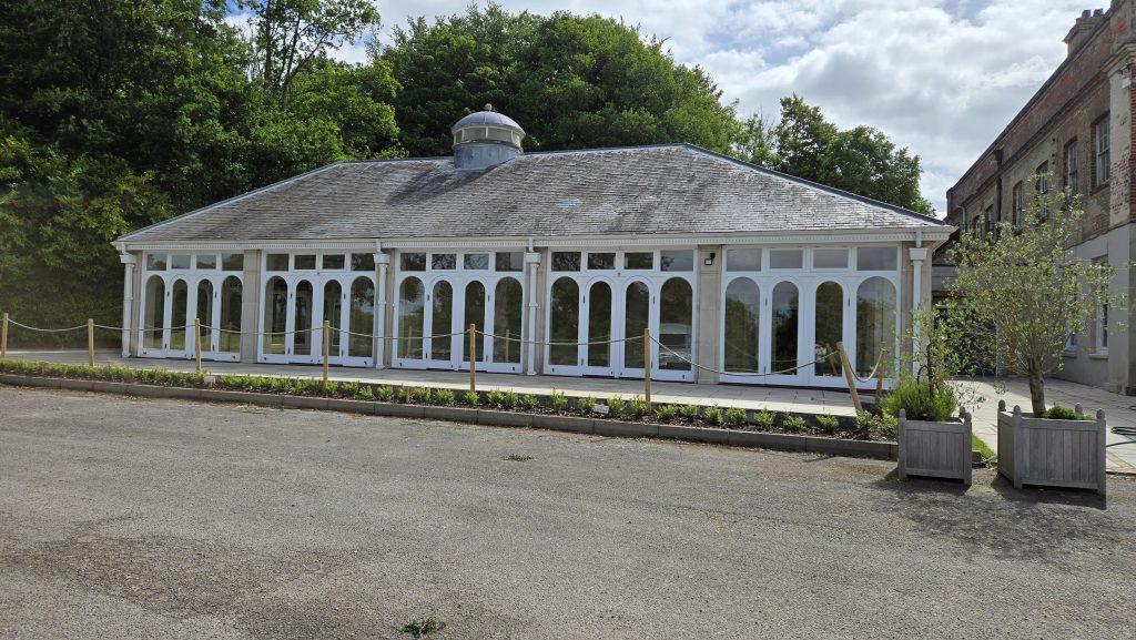The Orangery at Rookesbury Park, a bright and elegant wedding venue in Hampshire with large arched windows and a countryside backdrop.