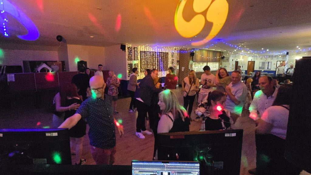 Guests dancing under colourful lights at a birthday party DJ set by Heard The Beat at Southsea Golf Club in Portsmouth