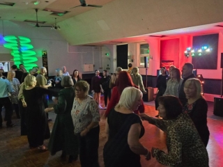 Guests dancing on a busy dance floor at a birthday party with colourful DJ lighting by Heard The Beat in Portsmouth