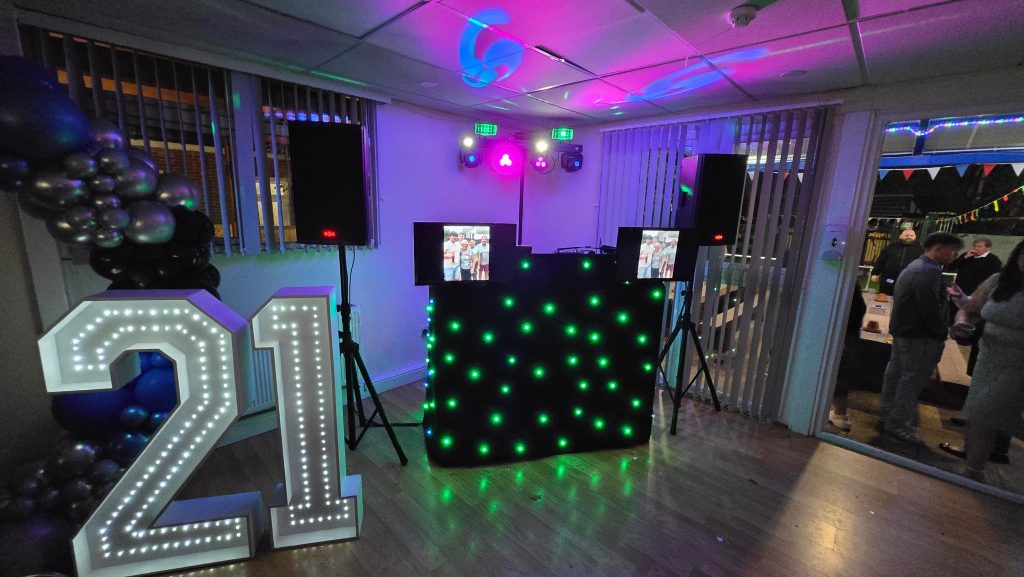 DJ setup featuring starlit booth, twin display screens, and illuminated 21 numbers for a 21st birthday party in Portsmouth.