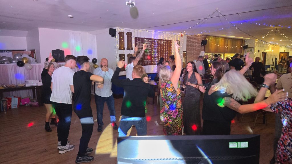Guests dancing with colourful lights and lively atmosphere at a birthday celebration in Portsmouth, DJed by Heard The Beat.