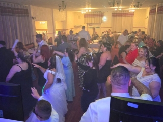 Wedding guests and the bride enjoying the dancefloor during a lively evening reception with DJ entertainment by Heard The Beat.