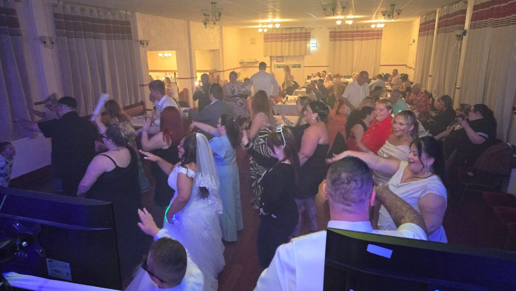 Wedding guests and the bride enjoying the dancefloor during a lively evening reception with DJ entertainment by Heard The Beat.