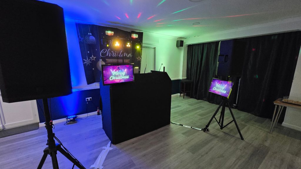 DJ karaoke setup with song selection screen and microphones at a party