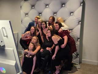 Smiling group photo taken using a Magic Mirror photo booth with luxury backdrop at a Portsmouth event