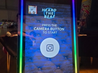 Heard The Beat interactive mirror photo booth with RGB LED lighting and touchscreen display at a party event