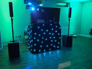 Professional school event DJ setup with LED starcloth booth, speakers and colourful lighting ready for a school disco