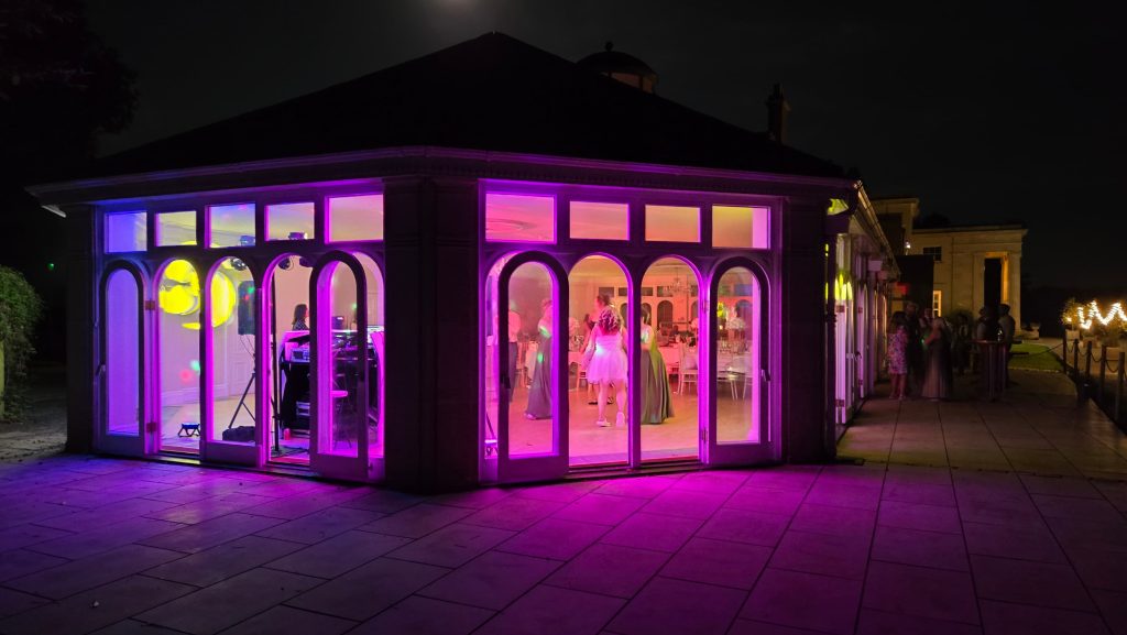 Evening wedding reception in Hampshire with DJ lighting and guests dancing at a countryside venue