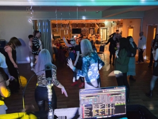 Crowd enjoying a 21st birthday party at Havant Rugby Club with DJ booth and lighting creating a lively atmosphere