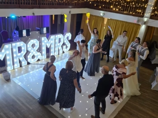 Guests dancing with Mr and Mrs light up letters at Royal Maritime Hotel Portsmouth wedding