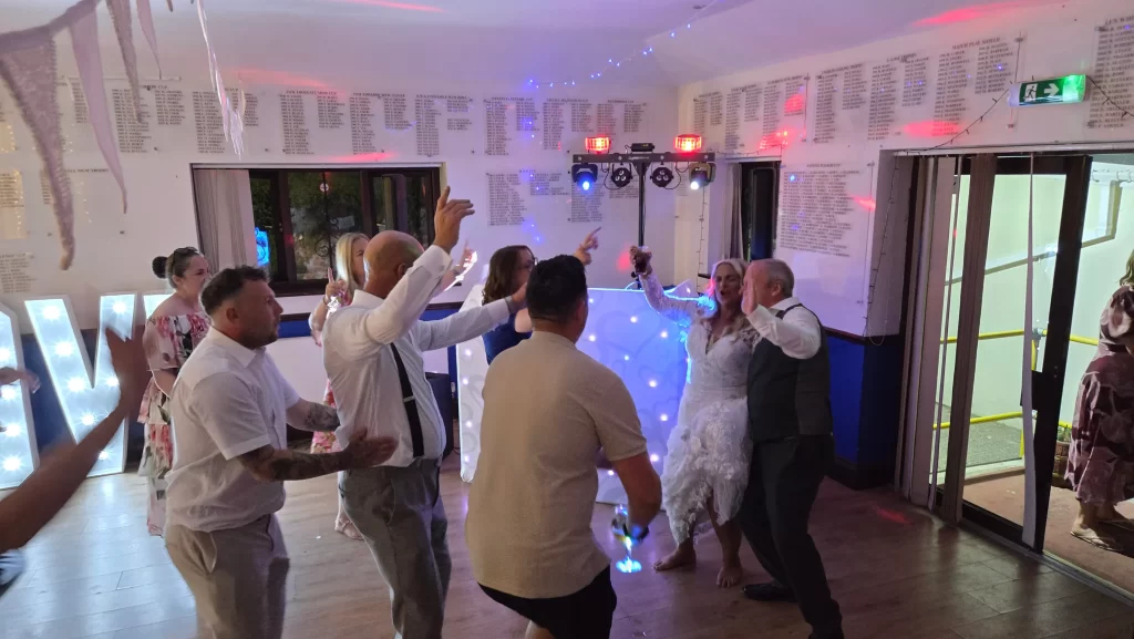 Wedding guests singing along and celebrating together during the evening reception