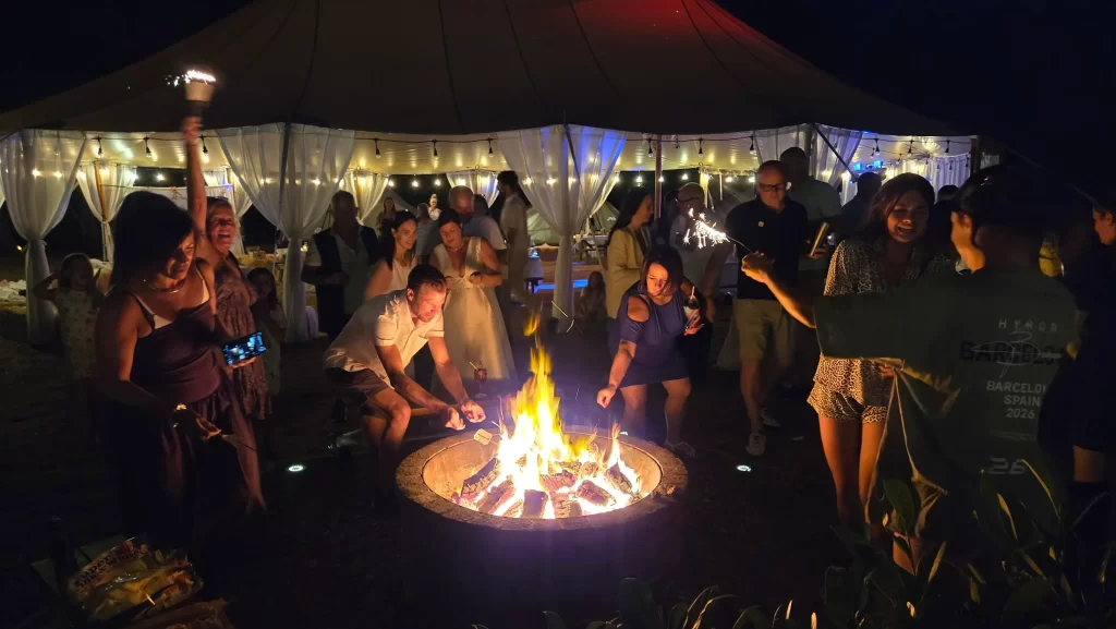 Wedding guests enjoying the fire pit at Bell Tent Glamping Southampton