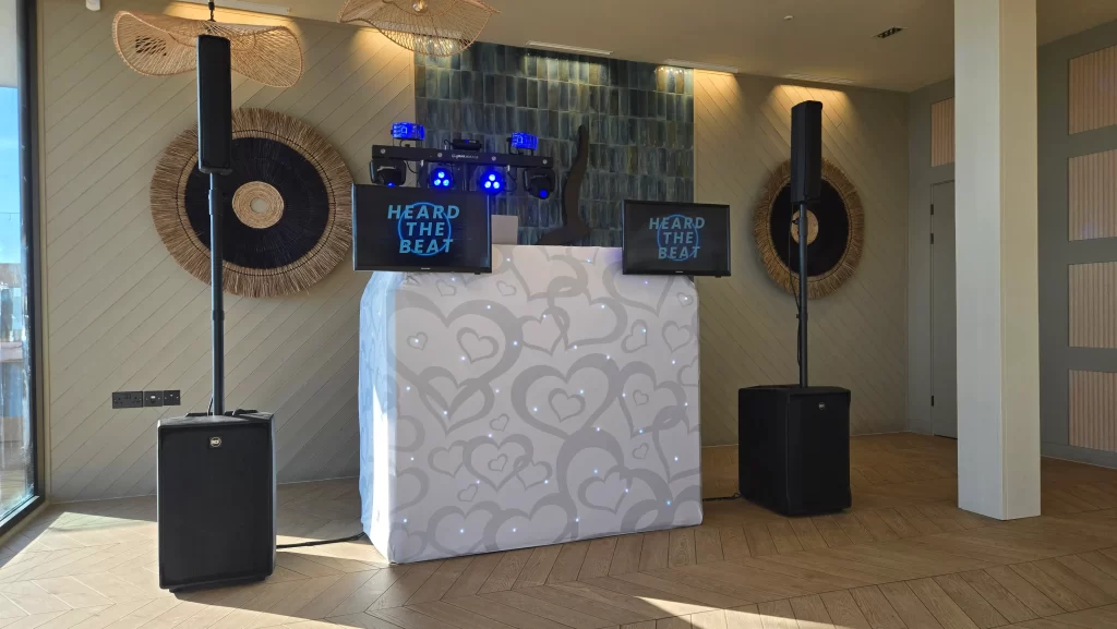 Heard The Beat wedding DJ setup with illuminated booth, screens, speakers and lighting